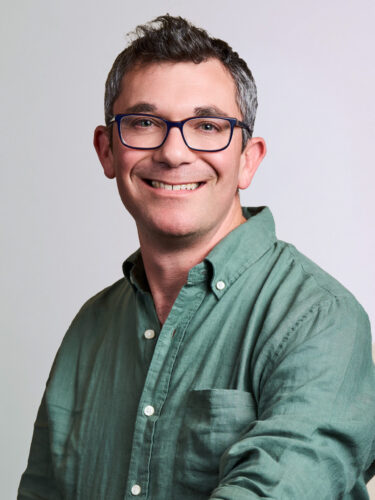 David Nahmias, a man with graying hair and glasses, wearing a green button-down shirt.